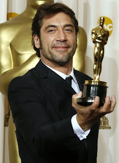 Javier Bardem posing for a picture while holding the award