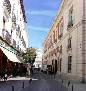 Vista de la corta y estrecha calle, entre los laterales de aire neoclásico de la Casa de Correos y las Casas de Cordero.