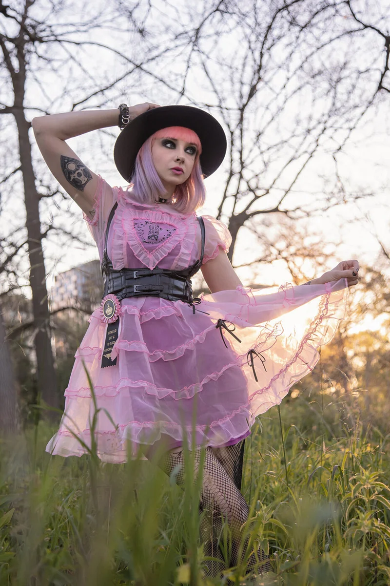 beautiful young woman in a pastel witchy outfit is posing for the camera