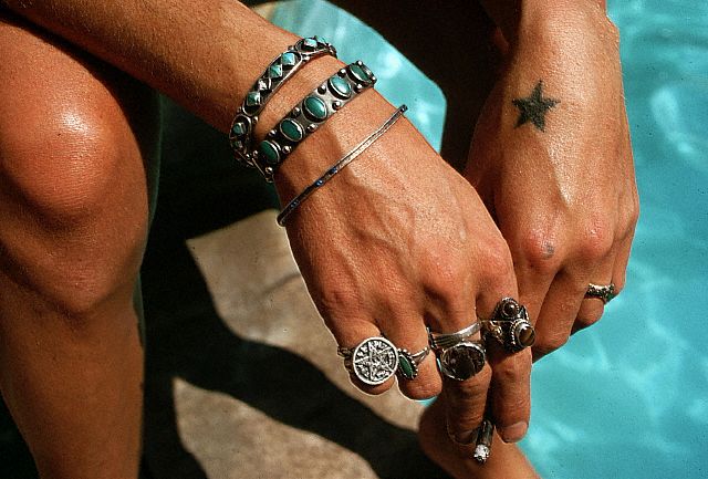 Small black star tattoo on a man's hand