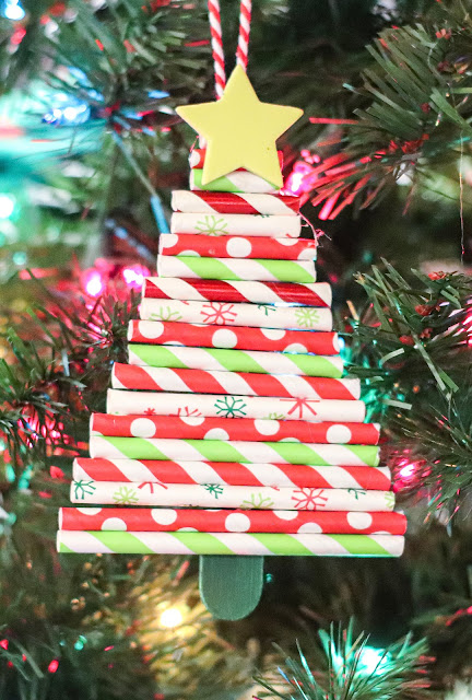 ornament hanging on a christmas tree with colored lights shining.