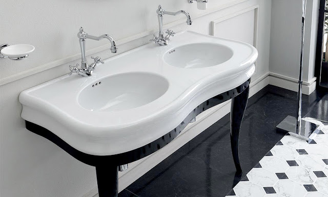 Curved front console sink with white sink and black legs.