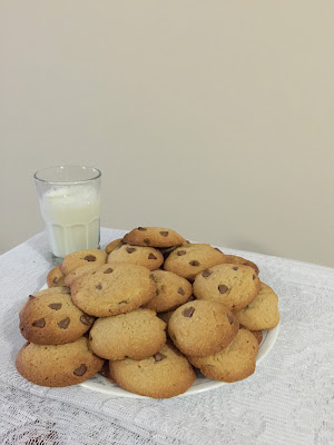 choc chip cookies on a plate with milk