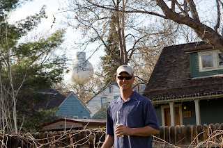 a man in a backyard with houses and a water tower