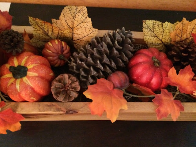 I enjoy mixing neutral shades with the traditional orange and yellows of fall to create a rustic fall mantel and wooden toolbox centerpiece.