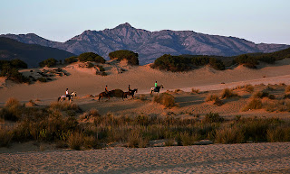 foto con panoramica montagne e persone a cavallo