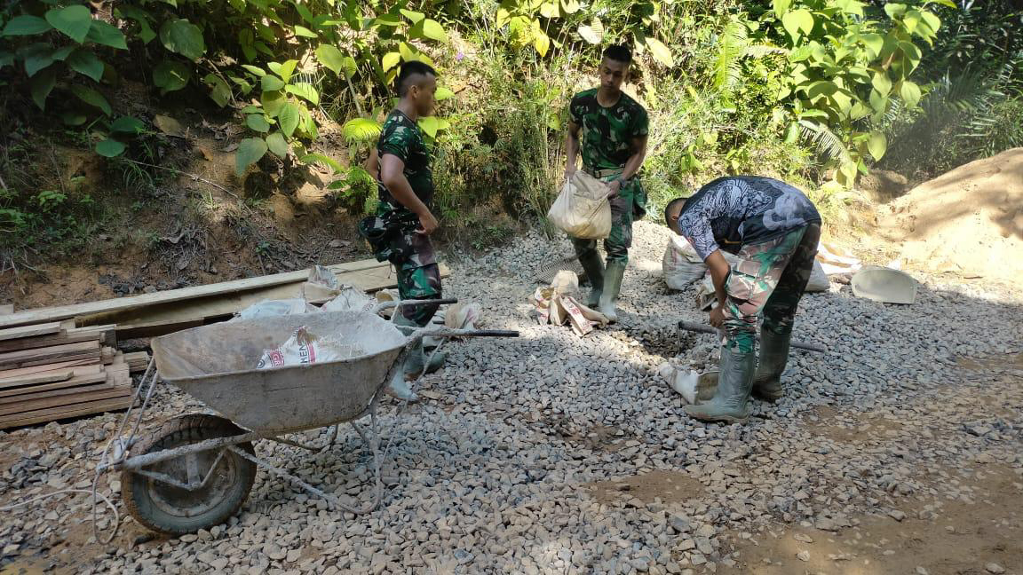 Dibawah Terik Matahari Satgas dan Warga Kumpulkan Batu Kerikil.