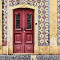 Purple door surrounded by boldly patterned azulejos in Beja Portugal