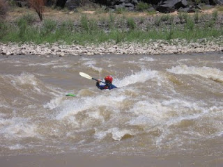 Aspen Kayak Academy student in the standing wave at 'Little D' rapids in Westwater Canyon