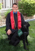 Bryan Goings in his graduation uniform with guide dog puppy