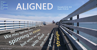 Pier boardwalk bearing the words "aligned: We may feel like we're spinning in circles, but when we walk with God, our steps are perfectly straight