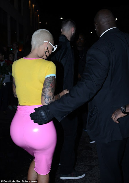 Anything Kim can do... Amber Rose parades pert posterior in bright pink PVC skirt as she leaves birthday party after reigniting Kardashian family feud