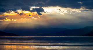 Scenic Crepuscular rays of light poke through the clouds on the Mountains of Okanagan Valley viewed from Kelowna by Chris Gardiner Photography www.cgardiner.ca