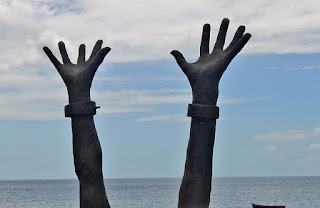 Slavery image: hands held up with broken chains