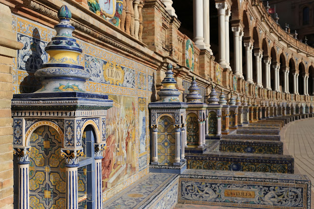 Bancos de azulejos y columnas de la fachada de un edificio semicircular.