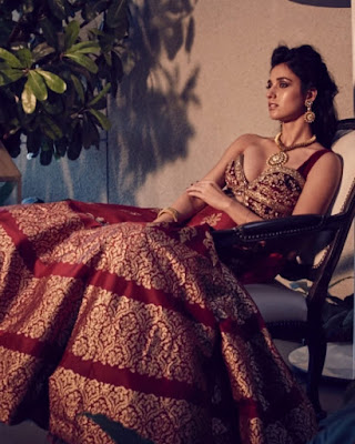 Disha Patani lying on lounger wearing red ethnic dress revealing her bulging breasts