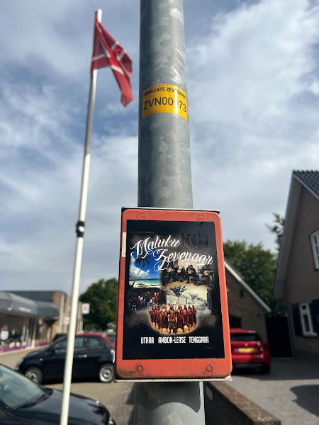 Aanwijsplaat met sticker 'Maluku Zevenaar', Zevenaar. OP de