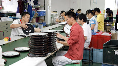 obreros en una fabrica montando partes de relojes