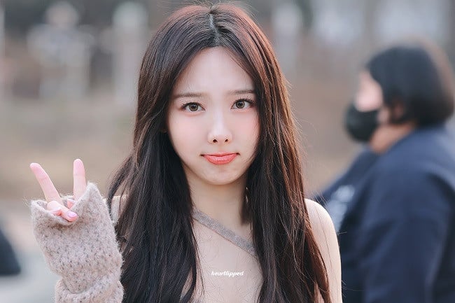 la cara de Nayeon, mostrando su belleza juvenil y su maquillaje impecable.