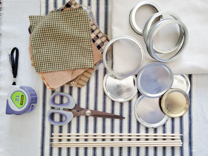 fabric, mason jar lids and rings, dowel rods