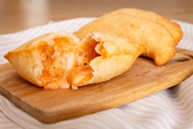 Gustoso panzerotto fritto con evidente e fuoriuscita di mozzarella.