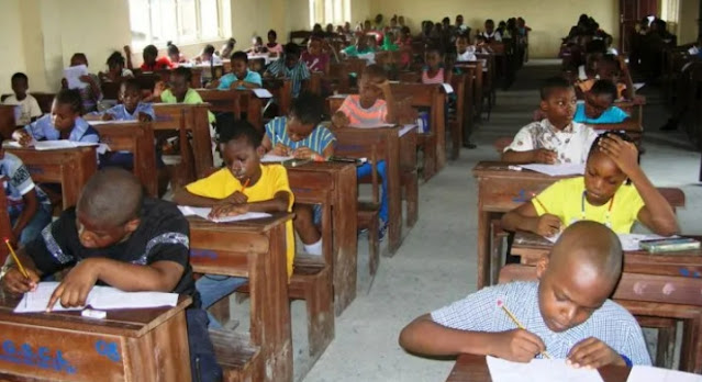 Alt: = "School children writing exam in Nigeria"
