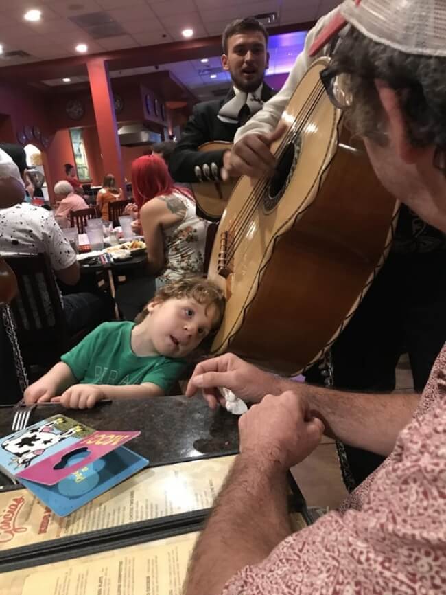 15 Powerful Pictures That Will Make Your Day - A musician let this hard-of-hearing little boy put his head on the guitar so he could hear it.