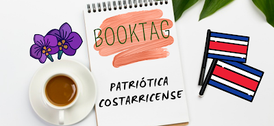 Una taza de café con leche junto con una libreta y del otro lado un par de lápices de blanco y negro, además de las hojitas verdes de una planta en la esquila. En la libreta hay una pincelada en rosa pálido con el título BookTag en verde oscuro, abajo en negro dice Patriótica costarricense.