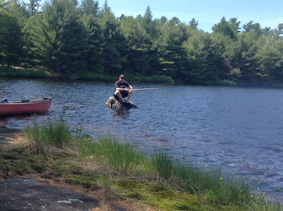 Porter sitting on a rock fishing