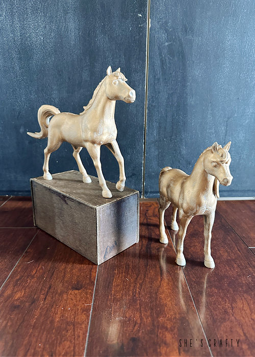 Painted horse statue with gold rub and buff.