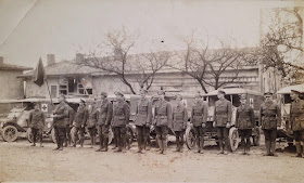 A photograph showing a line of men in uniform in front of ambulances.