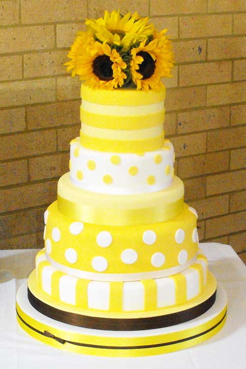 Yellow and white polka dot and stripes wedding cake with sunflower cake 