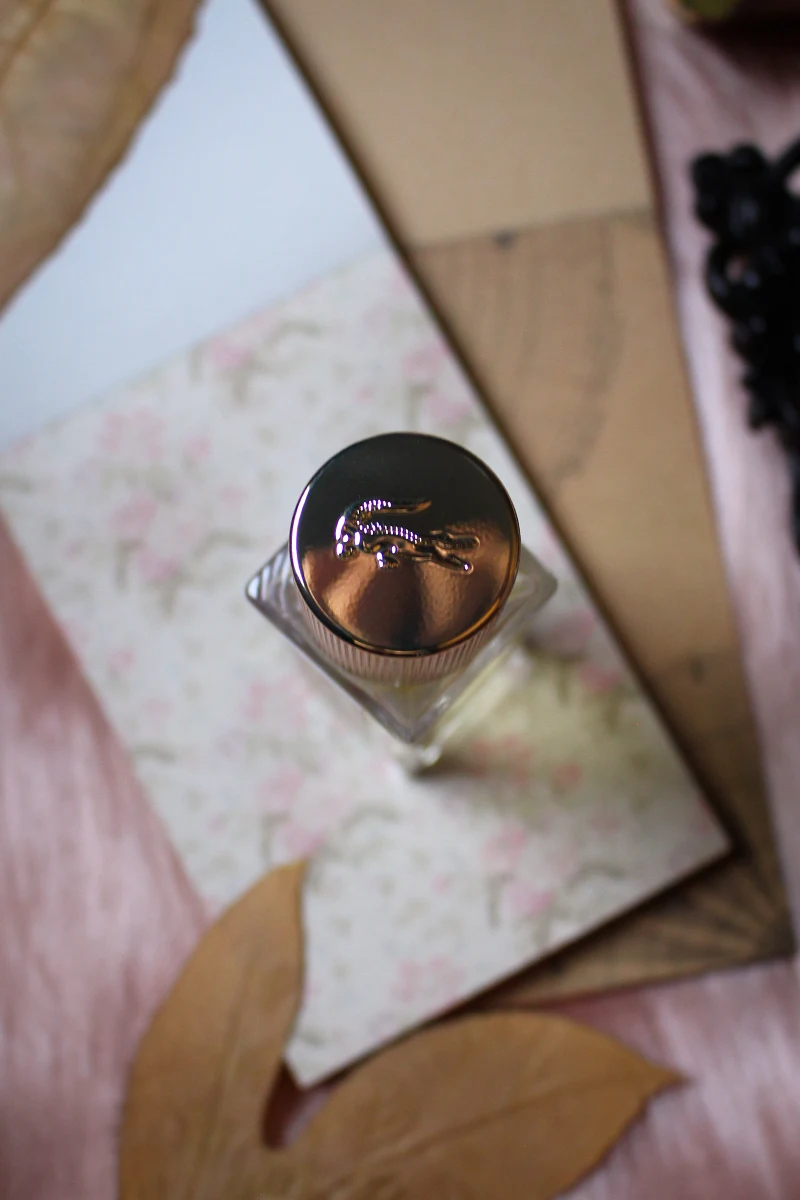 aestehtic close-up of Lacoste Pour Femme Eau De Parfum bottle beautifully arranged on a furry surface, under a cloudy day light