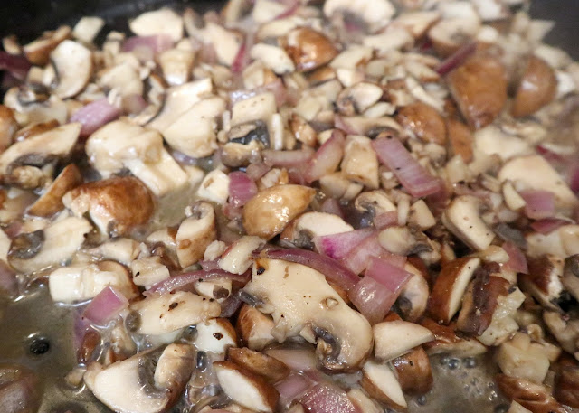 mushrooms and onions cooking in a pan