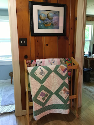 vintage quilts on display near knotty pine bedroom