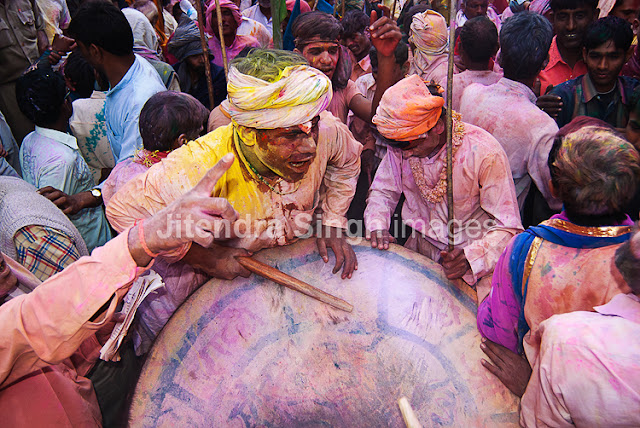 Here comes the very first and rocking PHOTO JOURNEY by Jitendra Singh, one of the great photographers. Photographers at PHOTO JOURNEY welcome Mr. Jitendra Singh and congratulate him for his first PHOTO JOURNEY with great colors. Let's check out these interesting Holi photographs from Barsana, Nandgaon, Goverdhan, Vrindavan and Mathura...The Hindu festival of Holi which is also called as the Festival of Colors celebrated with much enthusiasm in the month of Phalgun, which usually corresponds to the month of March. It marks the arrival of spring and the bright colors represent energy, life, and joy. The festival of colors is also very special for Photographers like Jitendra Singh, who visited one of the important places in India where Holi is celebrated in very special ways. This Photo Journey shares photographs from various parts of Uttar Pradesh.In Mathura, the birthplace of Lord Krishna and in Vrindavan this day is celebrated with special puja and the traditional custom of worshiping Lord Krishna, here the festival lasts for sixteen days. All over the Braj region and its nearby places like Hathras, Aligarh, Agra the Holi is celebrated in more or less same way as in Mathura, Vrindavan and Barsana. This great festival is associated with the immortal love of Lord Krishna and Radha and hence, Holi is spread over 16 days in Nandgaon, Barsana, Goverdhan, Vrindavan as well as Mathura - the cities with which Lord Krishna shared a deep affiliation. Apart from the usual fun with colored powder and water, Holi is marked by vibrant processions which are accompanied by folk songs, dances and a general sense of abandoned vitality. These photographs share the mood of Holi with great enthusiasm, music, dance and lot of excitement in various forms. Barsana is the place to be at the time of Holi. Here the famous Lath mar Holi is played in the sprawling compound of the Radha Rani temple. Thousands gather to witness the Lath Mar holi when women beat up men with sticks as those on the sidelines become hysterical, sing Holi Songs and shout Sri Radhey or Sri Krishna. The Holi songs of Braj mandal are sung in pure Braj BhashaHoli is known by the name of 'Dol Jatra', 'Dol Purnima' or the 'Swing Festival'. The festival is celebrated in a dignified manner by placing the icons of Krishna and Radha on a picturesquely decorated palanquin which is then taken round the main streets of the city or the village. The devotees take turns to swing them while women dance around the swing and sing devotional songs. During these activities, the men keep spraying colored water and colored powder, abir, at them.The Holi celebration has its celebration origins in Gujarat, particularly with dance, food, music, and colored powder to offer a spring parallel of Navratri, Gujarat's Hindu festival celebrated in the fall. Falling on the full moon day in the month of Phalguna, Holi is a major Hindu festival and marks the agricultural season of the Rabi cropOn Dol Purnima day in the early morning, the students dress up in saffron-colored or pure white clothes and wear garlands of fragrant flowers. They sing and dance to the accompaniment of musical instruments like ektara, dubri, veena, etc. Holi played at Barsana is unique in the sense that here women chase men away with sticks. Males also sing provocative songs in a bid to invite the attention of women. Women then go on the offensive and use long staves called lathis to beat men folk who protect themselves with shieldsIn Maharashtra, Holi is mainly associated with the burning of Holika. Holi Paurnima is also celebrated as Shimga. A week before the festival, youngsters go around the community, collecting firewood and money. On the day of Holi, the firewood is arranged in a huge pile at a clearing in the locality. 