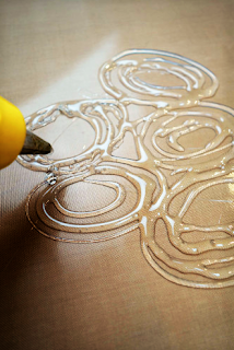 Try creating shapes with glue gun on a flat surface first before working on a bottle. 