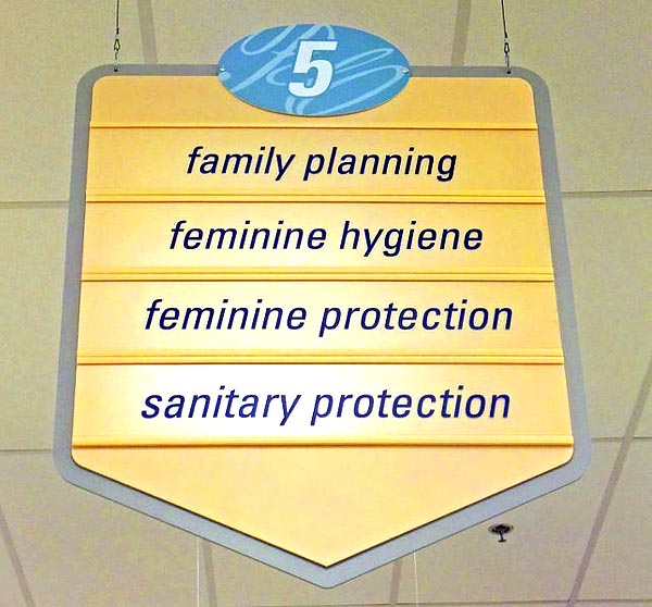 rugstore aisle sign reading family planning, feminine hygiene, feminine protection, and sanitary protection