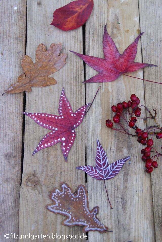 Rote Blätter vom Amberbaum und braunes Eichenlaub mit Kreidestift bemalen