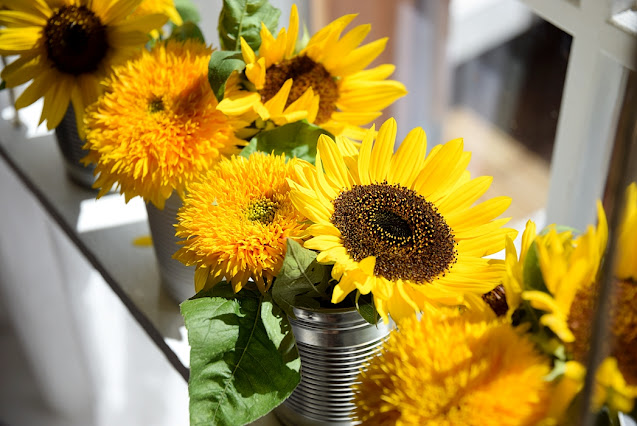 Blumendeko mit Sonnenblumen am Fenster