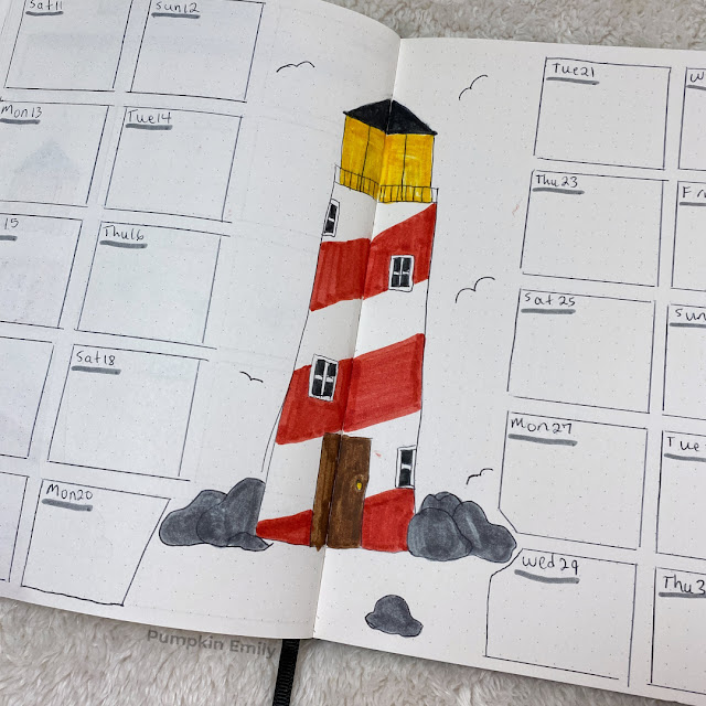 A close up of a two page weekly spread with a lighthouse in the middle.