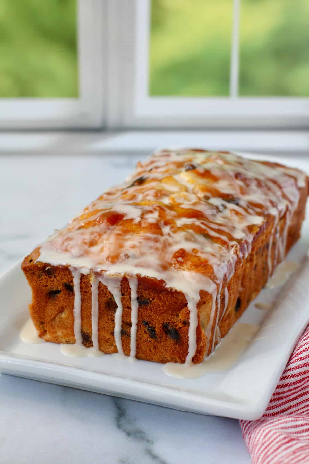 Classic French Apple Cake loaf on a white oblong plate.