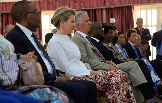 Queen Mathilde wore a white linen belted blouse and wide leg printed linen trousers from Natan. Dr. Denis Mukwege