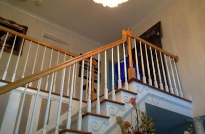 balconied staircase with white wooden pickets and natural wood handrails, treads