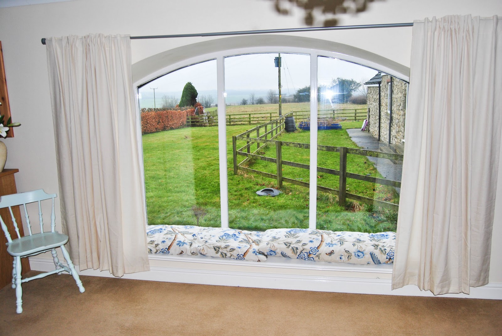 Window seat. Cushions made my mum. More beige curtains! title=