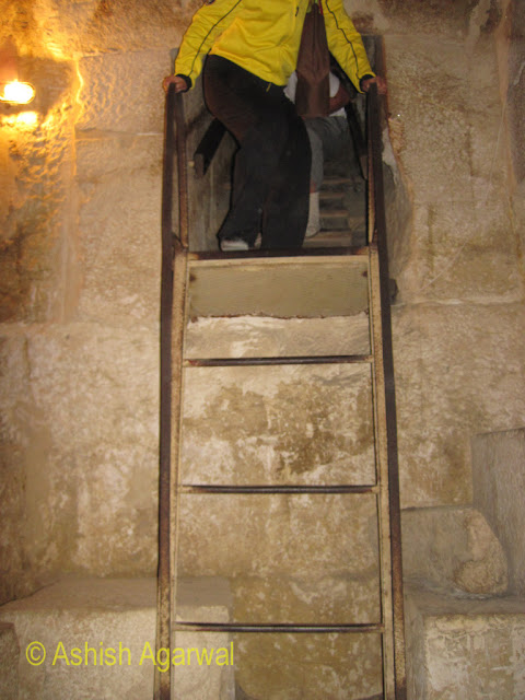 Cairo Pyramids - Tourist preparing to climb down the ladder leading to the burial chamber, in the structure next to the Great Pyramid