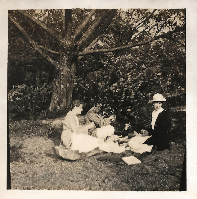 Three people picnicking in the woods, from the Smith family photos, around 1917