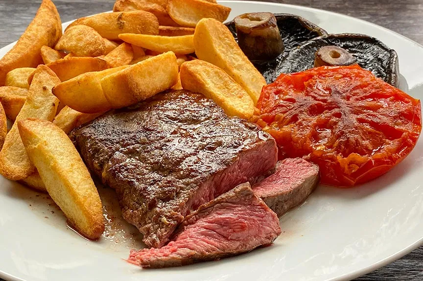 Flat iron steak with chips, mushrooms and tomato