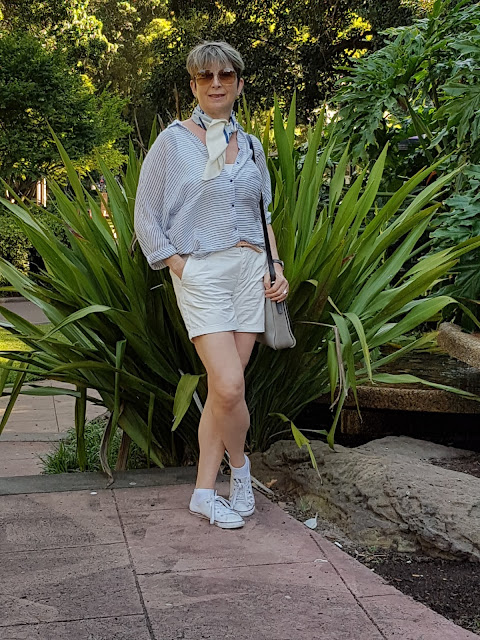 White shorts pared with sneakers, a blouse and vintage Pierre Cardin scarf