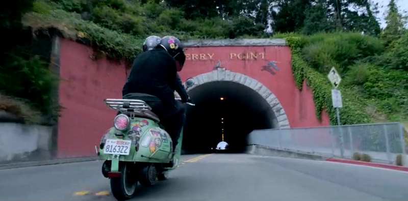 pink tunnel with two people riding a Vespa bike